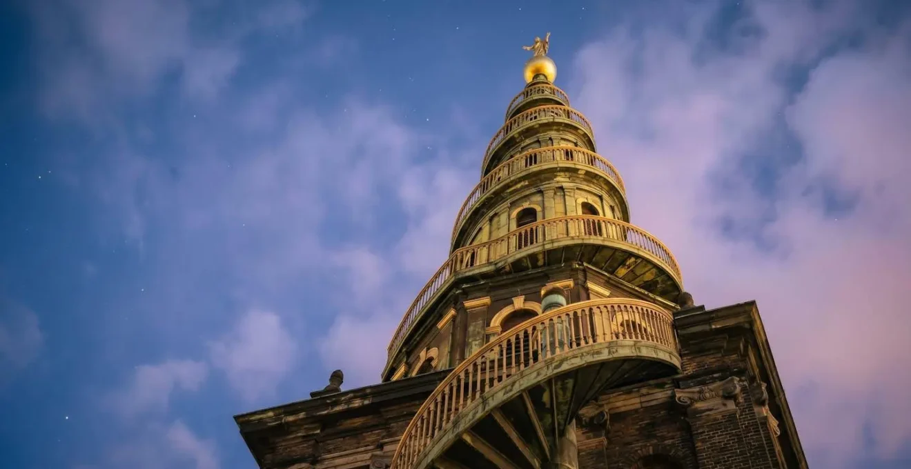 Golden baroque spiral spire of Church of Our Saviour in Christianshavn Copenhagen captured from low angle with dramatic sky
