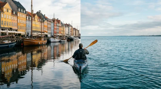 Wide panoramic view of a kayaker paddling between Copenhagen's colorful waterfront buildings and the vast open sea horizon