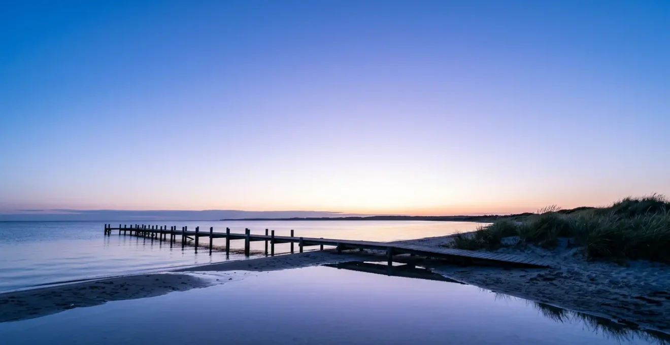 Danish coastal landscape during the blue hour of white nights showing ethereal twilight glow over calm waters