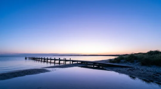 Danish coastal landscape during the blue hour of white nights showing ethereal twilight glow over calm waters